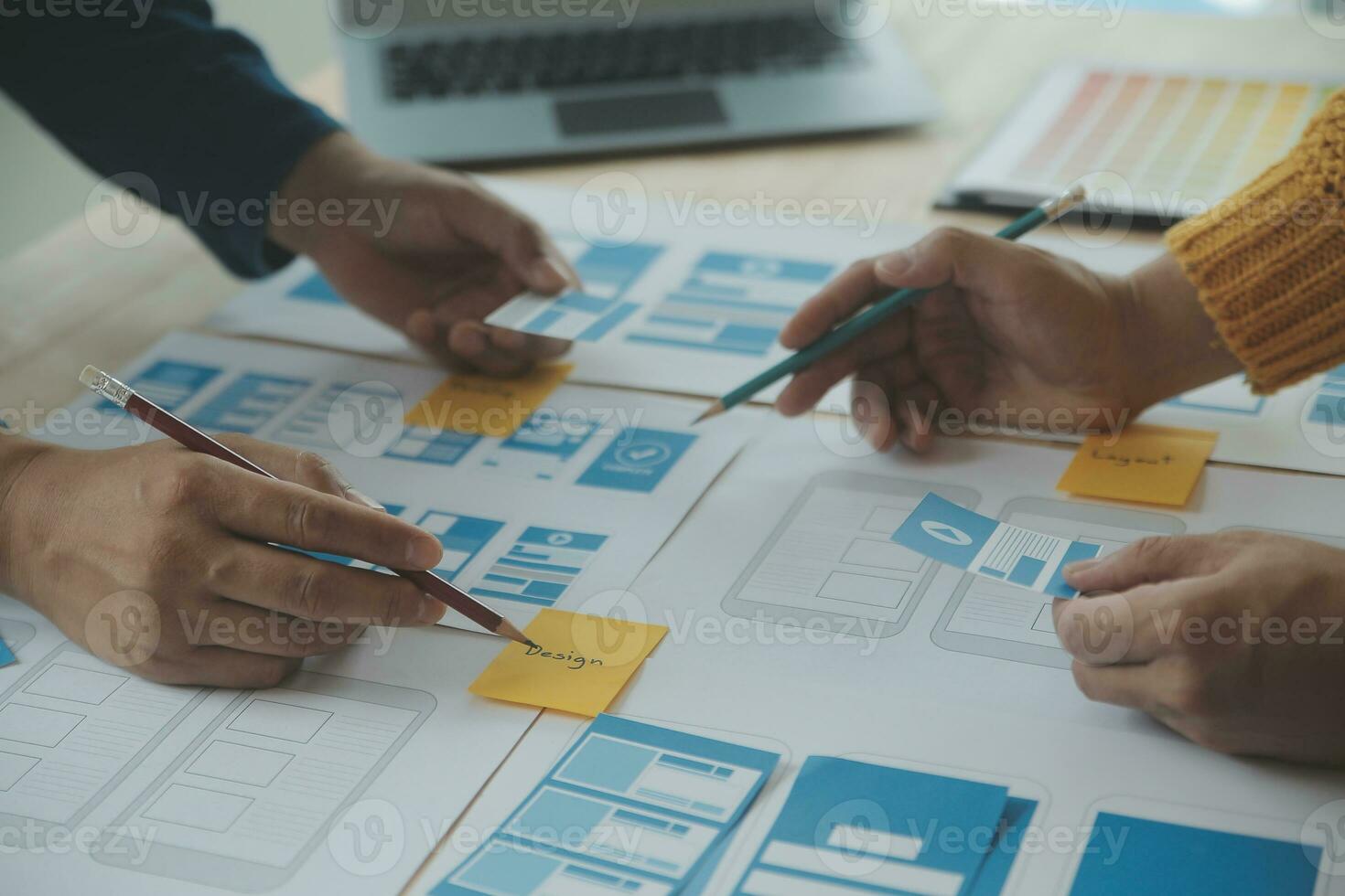 Close up ux developer and ui designer brainstorming about mobile app interface wireframe design on table with customer breif and color code at modern office.Creative digital development agency photo