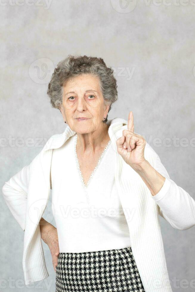 Senior old woman at the gray background photo