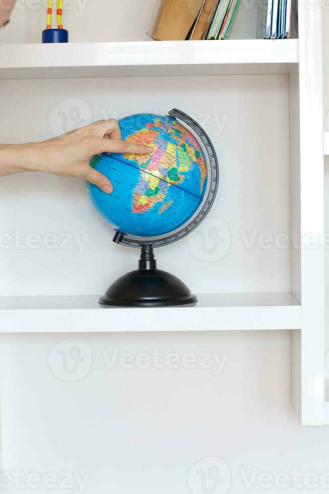 Colorful paper globe on a book shelf. photo