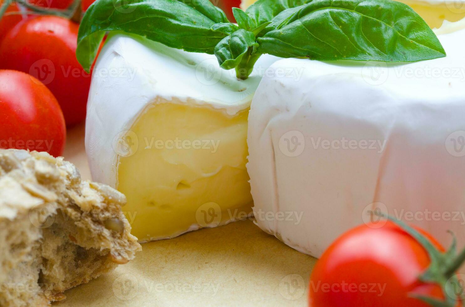 Stinky French cheese and red cherry tomatoes. Closeup photo