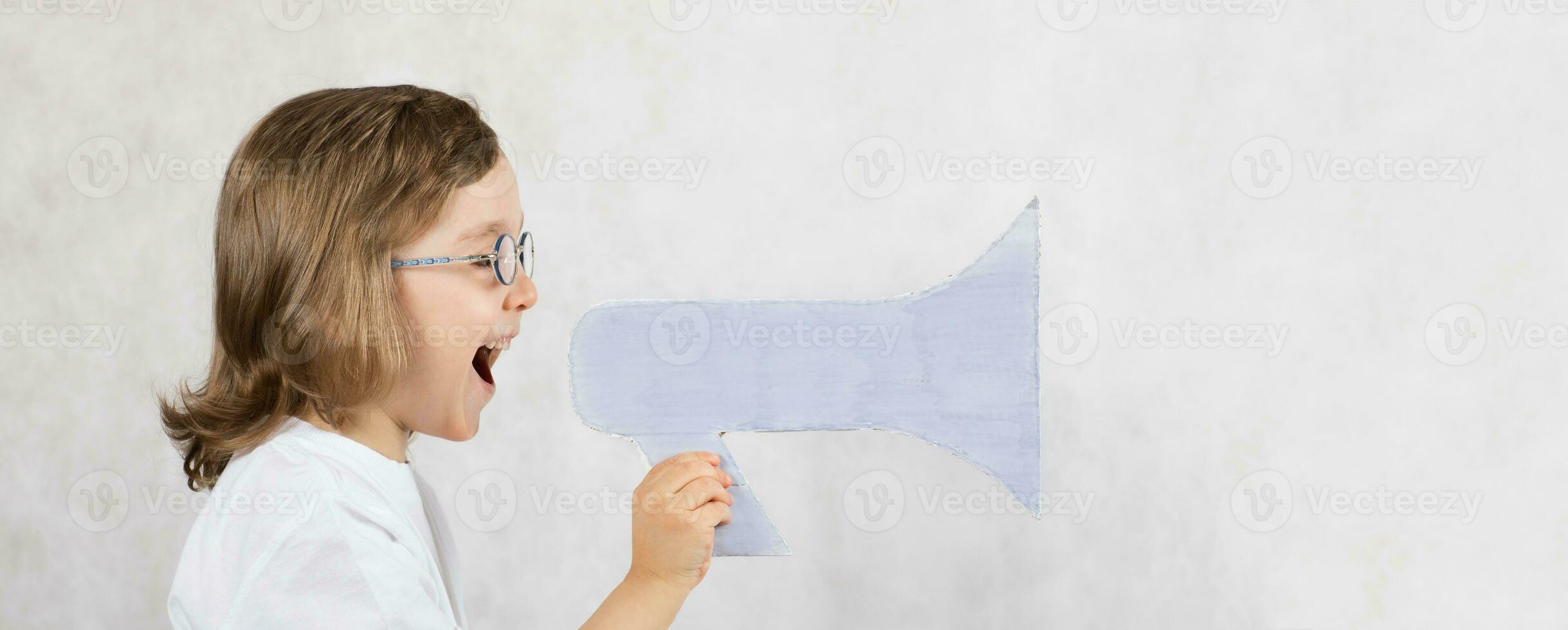 chico de cinco años es anunciando alguna cosa a altoparlante. foto