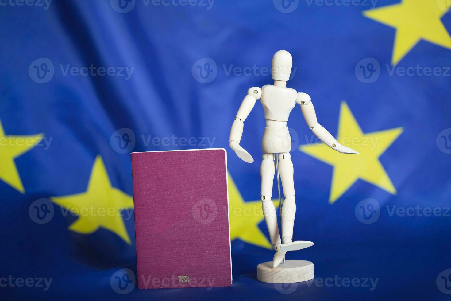 biométrico pasaporte y tonto figurilla en frente Vamos UE bandera. foto