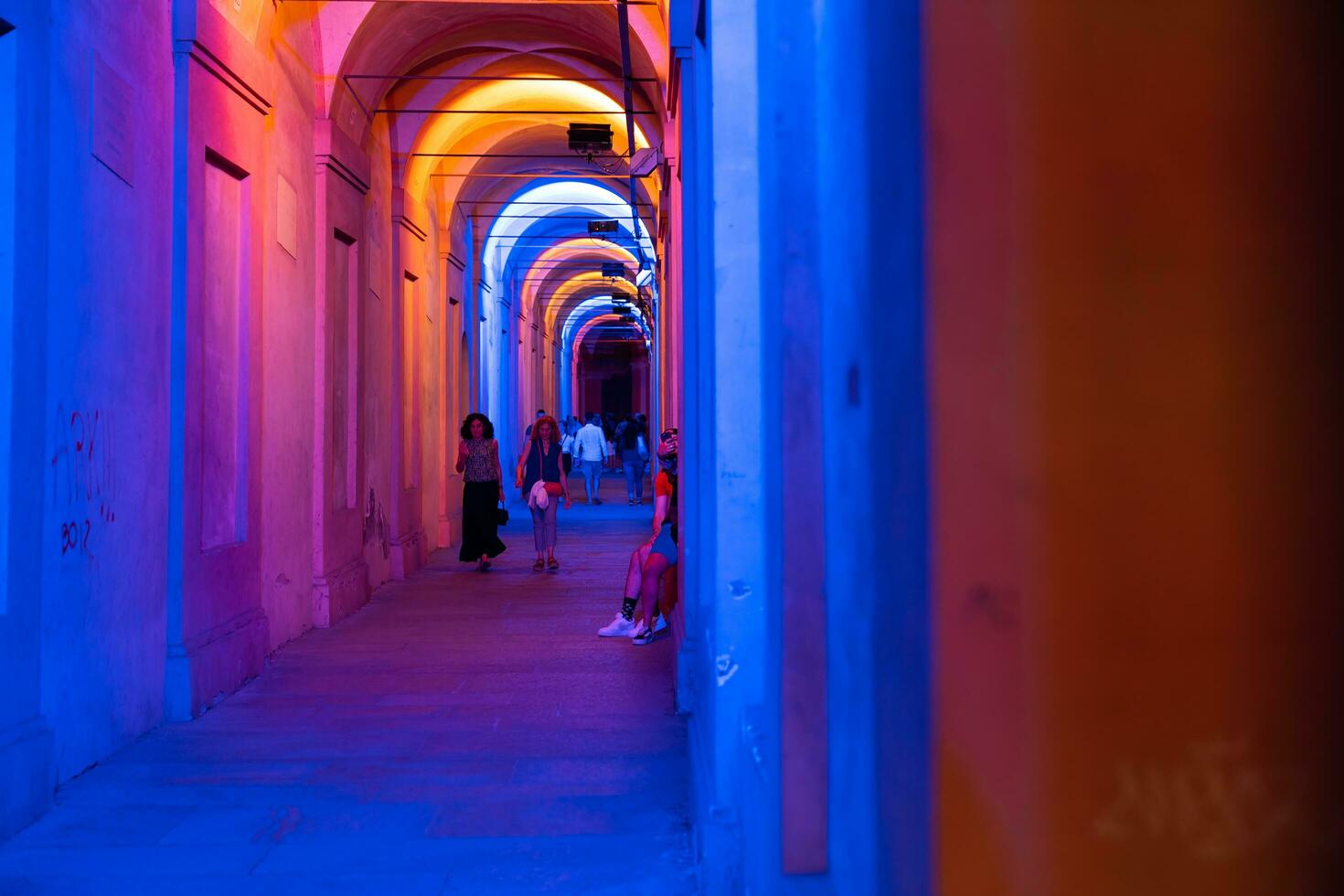 Bologna,Italy- June 23, 2023-People stroll at night under the arcades leading to the sanctuary of San Luca illuminated for the first edition of the Bologna arcades Festival. photo