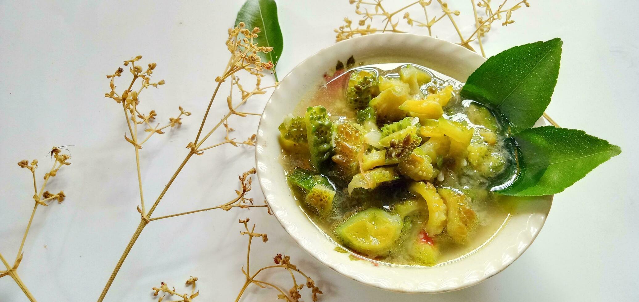 Anti diabetic food- bitter melon dish or tumis pare with on the white background photo