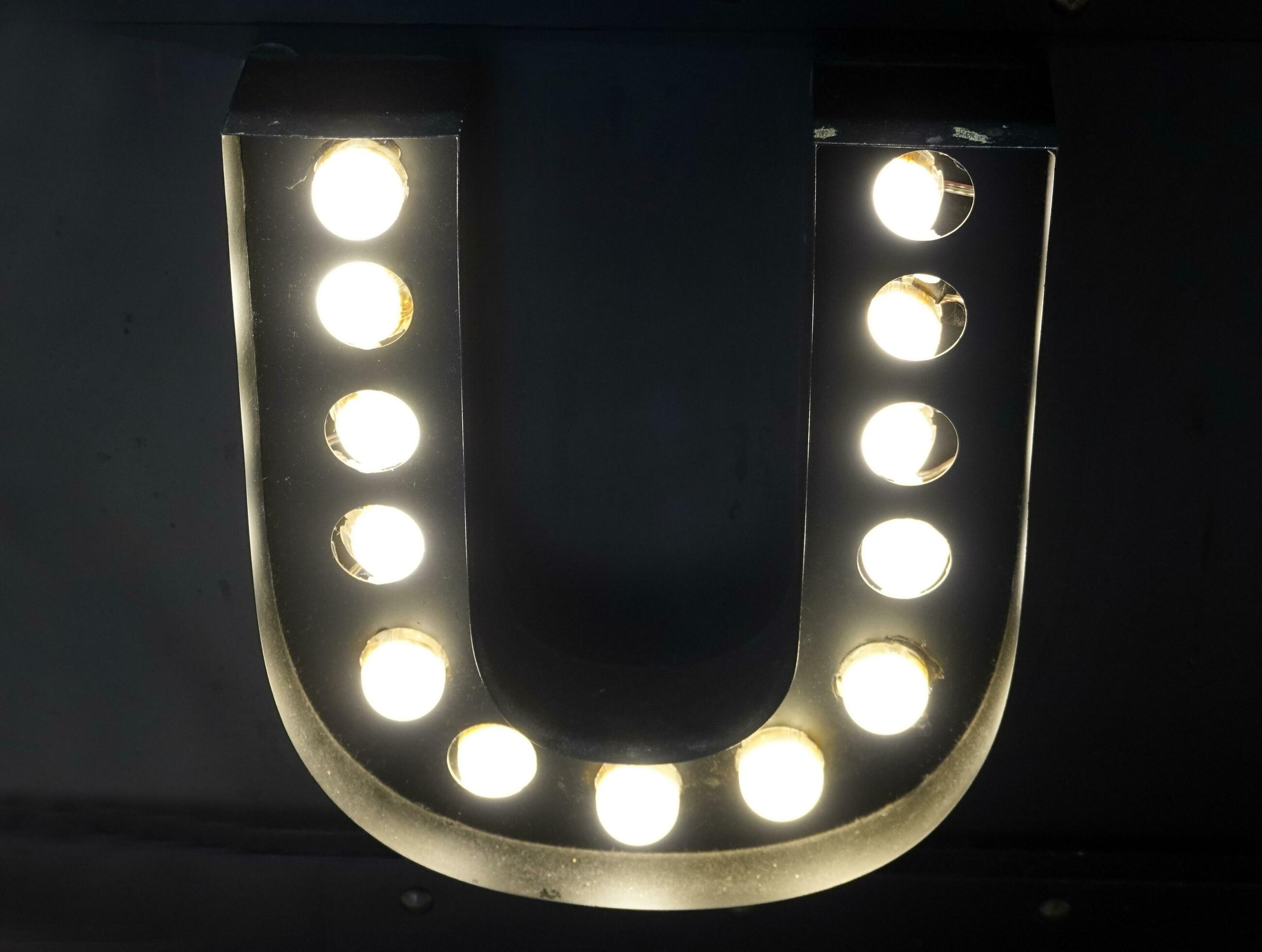 Light bulb glowing letter alphabet character U font. Front view
