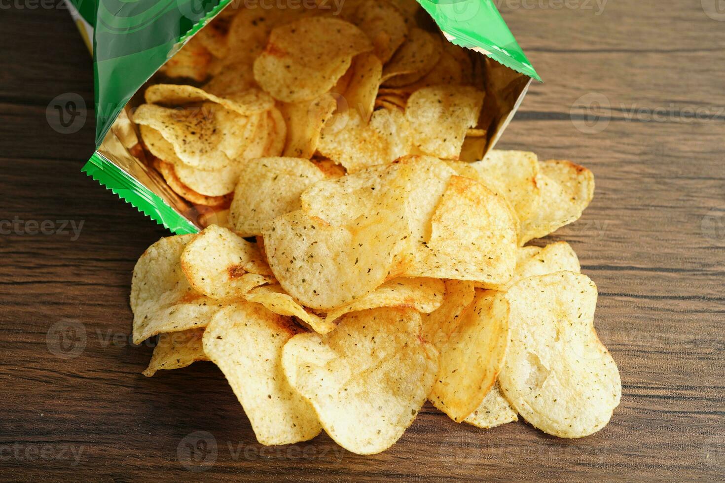 papas fritas en bolsa abierta, delicioso condimento de barbacoa picante para crips, refrigerio frito en rodajas finas comida rápida en bolsa abierta. foto