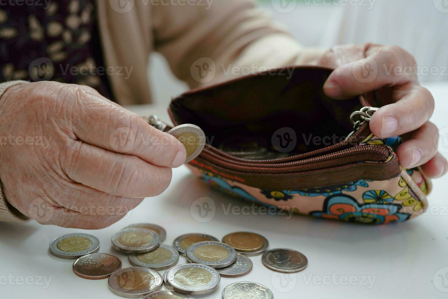 Retired elderly woman counting coins money and worry about monthly expenses and treatment fee payment. photo
