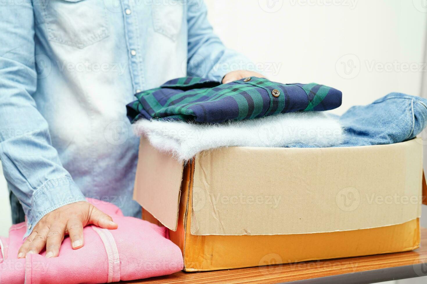 Clothes donations in cardboard box for volunteer. photo
