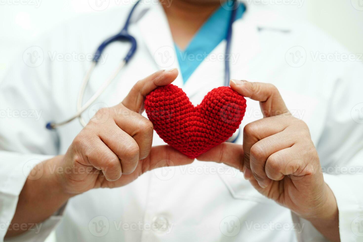 Asian woman doctor holding red heart for health in hospital. photo