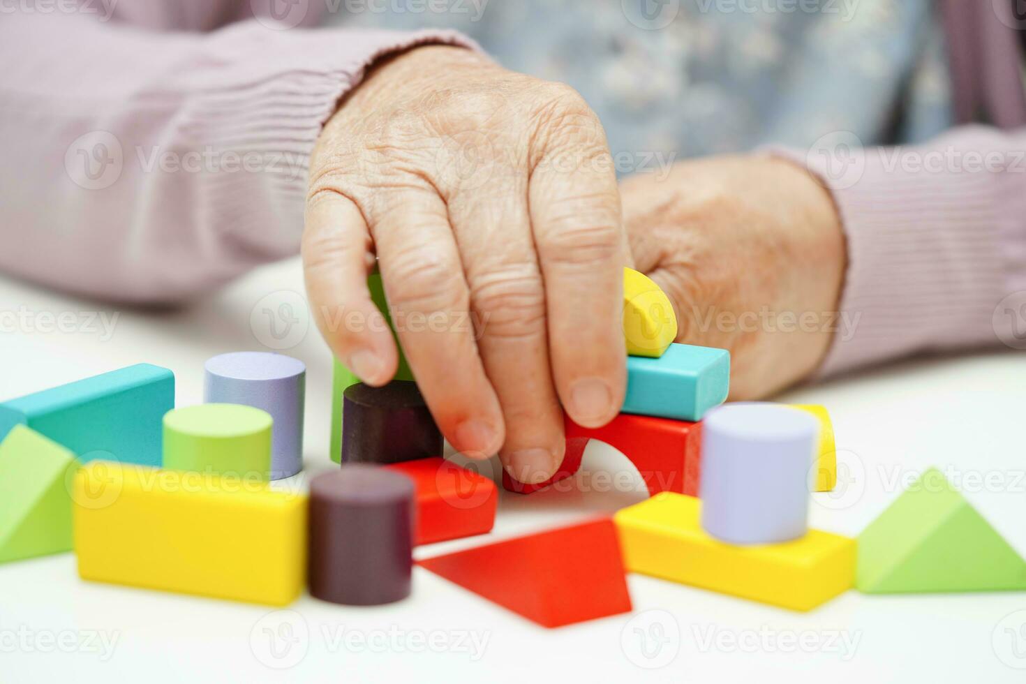 Asian elderly woman playing puzzles game to practice brain training for dementia prevention, Alzheimer disease. photo