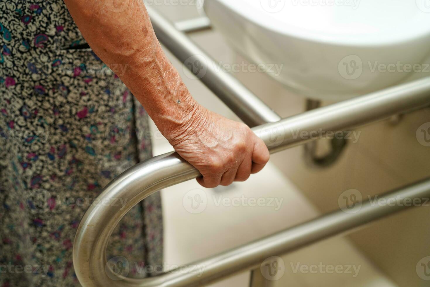 Asian elderly old woman patient use toilet support rail in bathroom, handrail safety grab bar, security in nursing hospital. photo