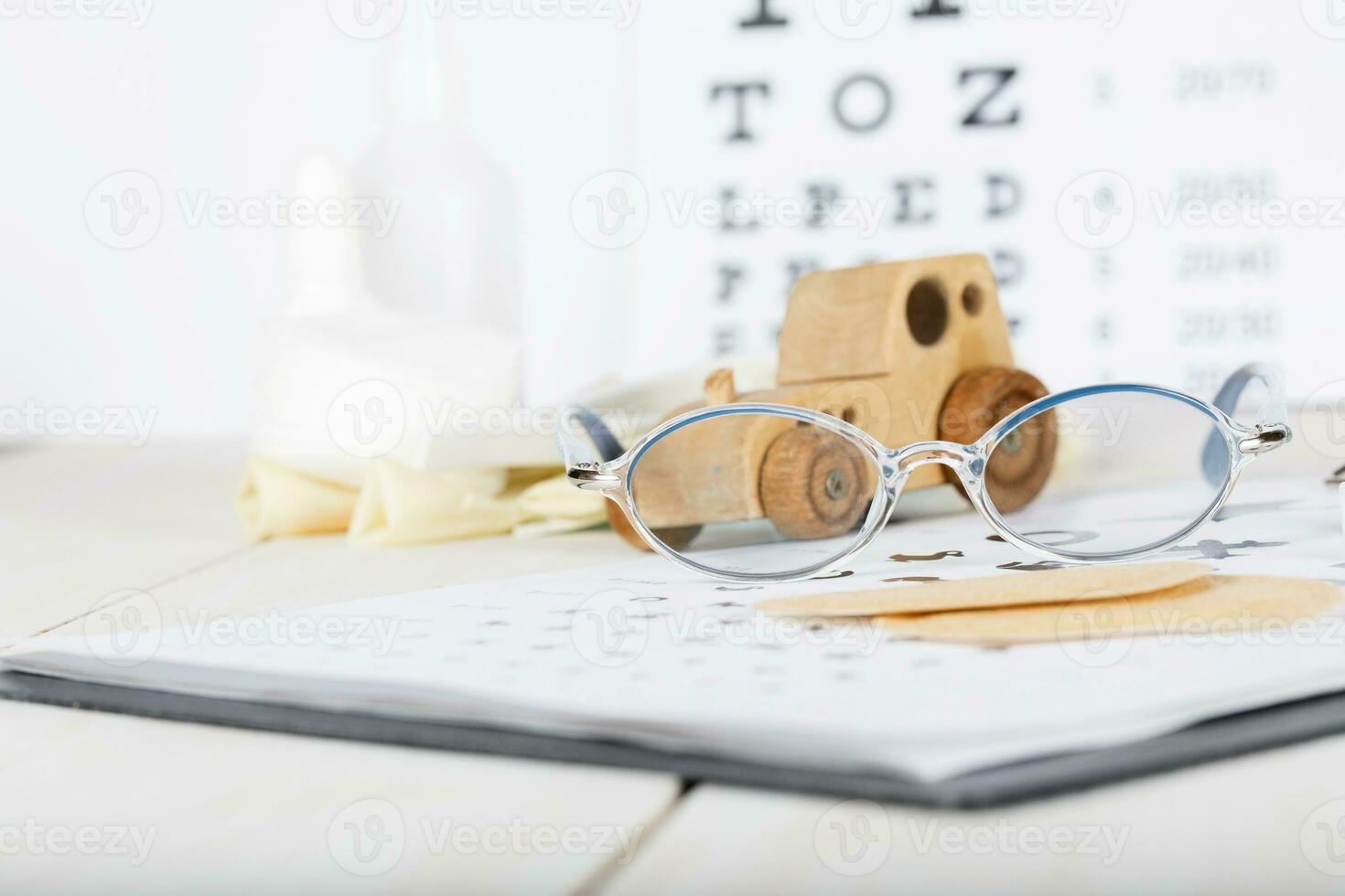 Eyeglasses for children on a eye chart close to eye pads. photo