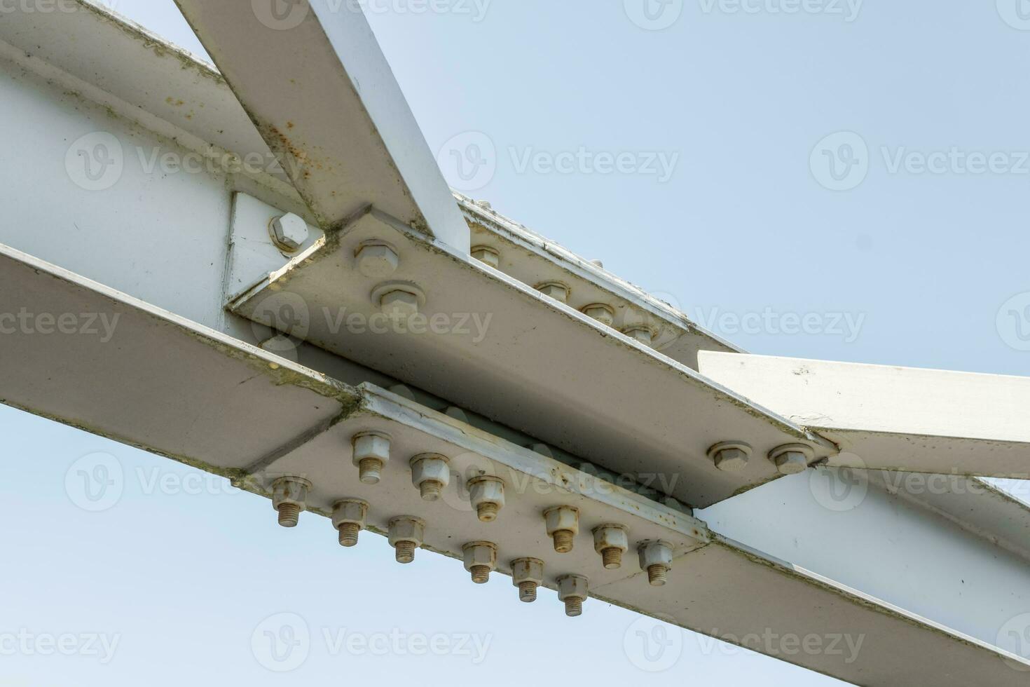 Bolts and nuts on metal plates of steel structure of heavy duty straight crossbar of frame and bridge support photo