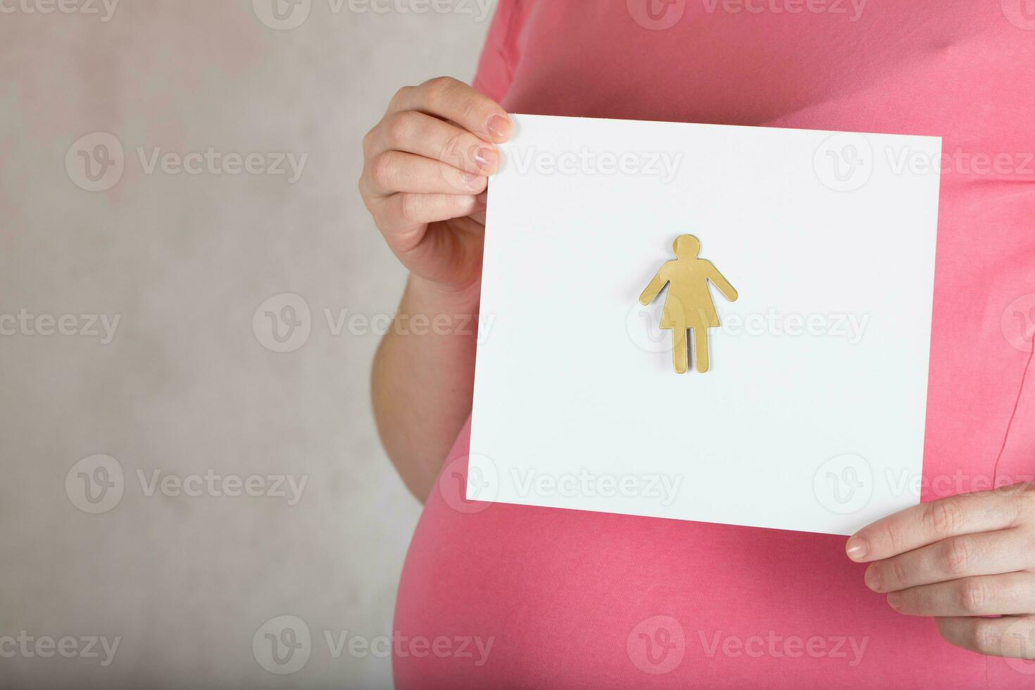 Young pregnant between 30 and 35 years old woman keeps a  blank white sheet of paper. photo