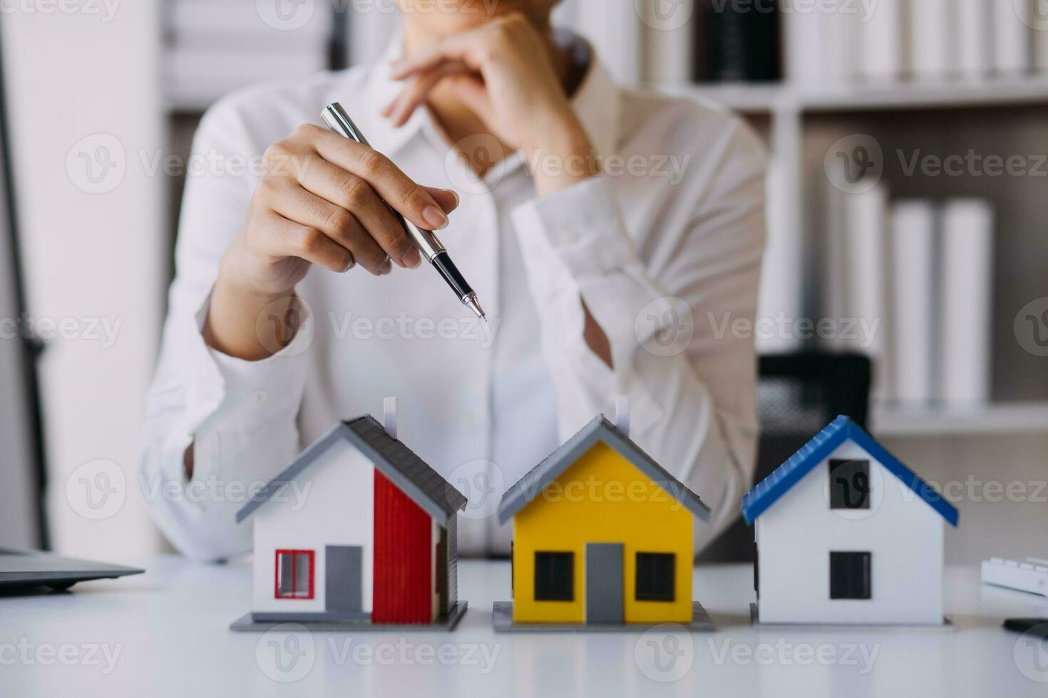 A couple is approaching a housing project to buy, and they are discussing details and advice with a salesperson in a housing project. Real estate trading ideas with couples. photo