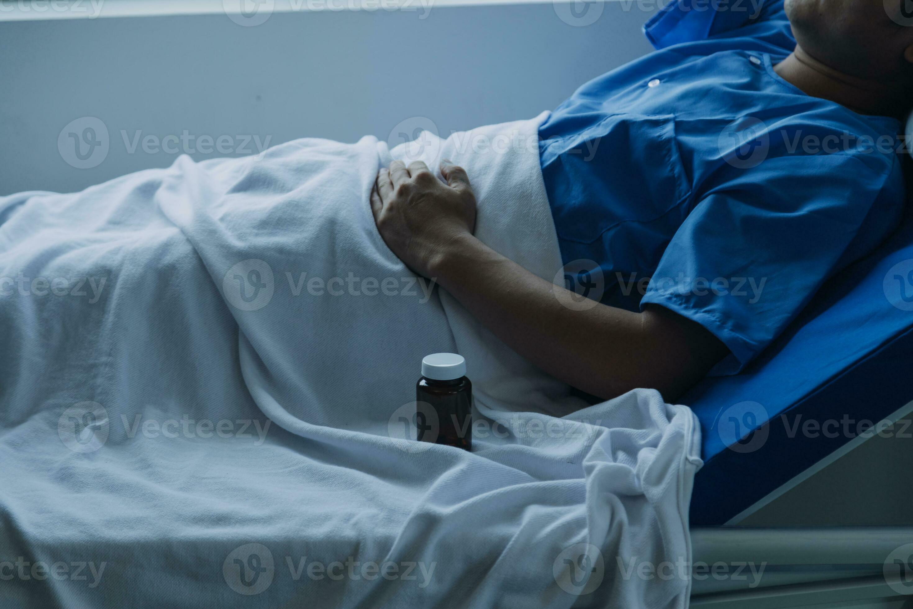 young injured man in hospital room sitting alone in pain looking