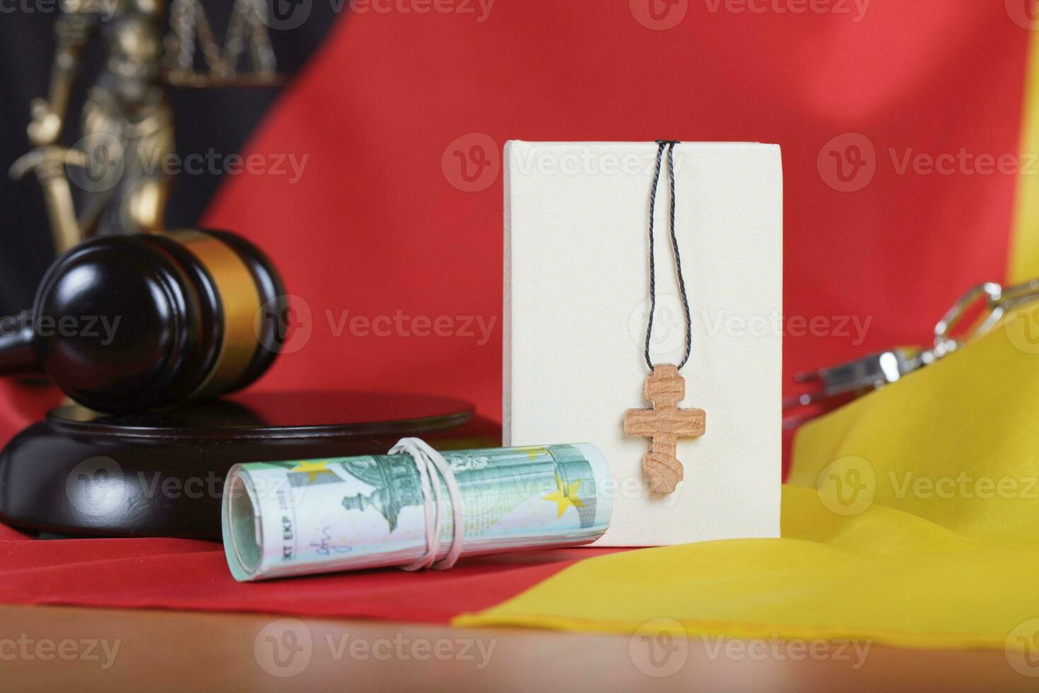 Bible and wooden cross placed close to money. photo