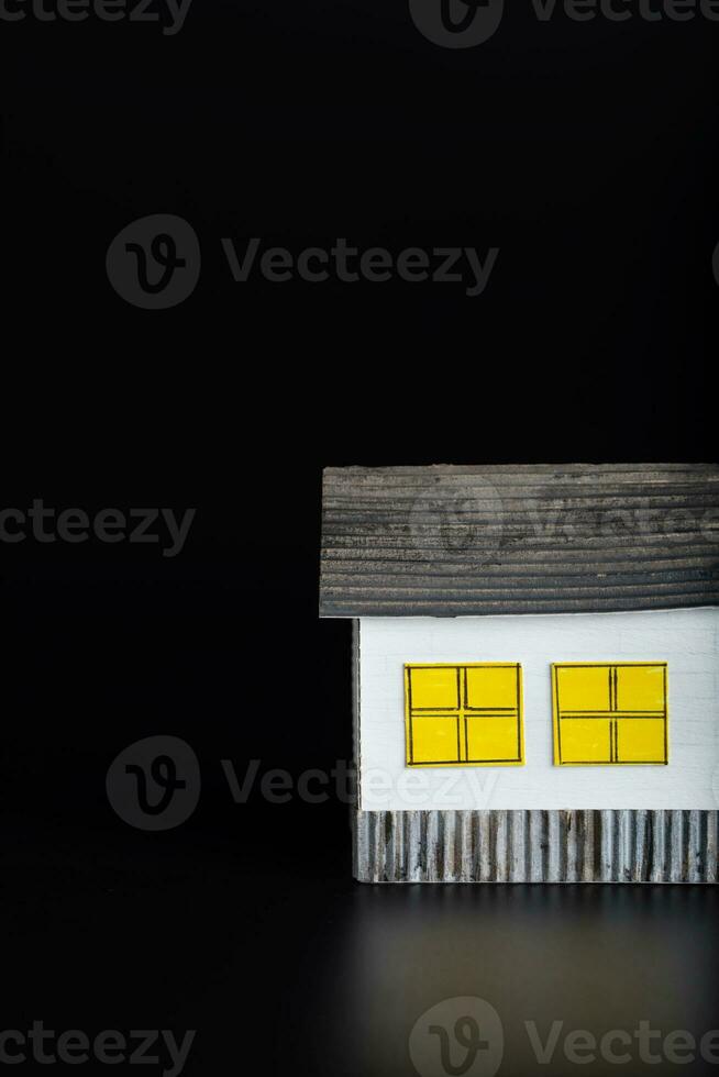 Small paper house on a black surface. photo