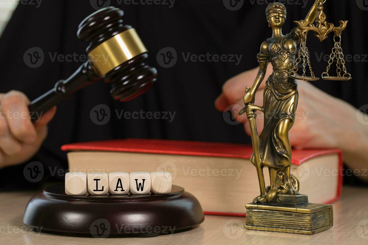Word LAW composed of wooden dices. Wooden gavel and statue of Themis in the background. photo