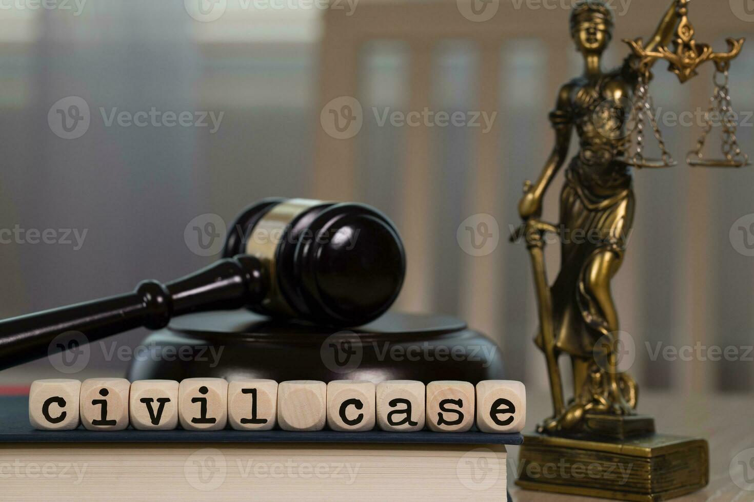 Words CIVIL CASE composed of wooden dices. Wooden gavel and statue of Themis in the background. photo