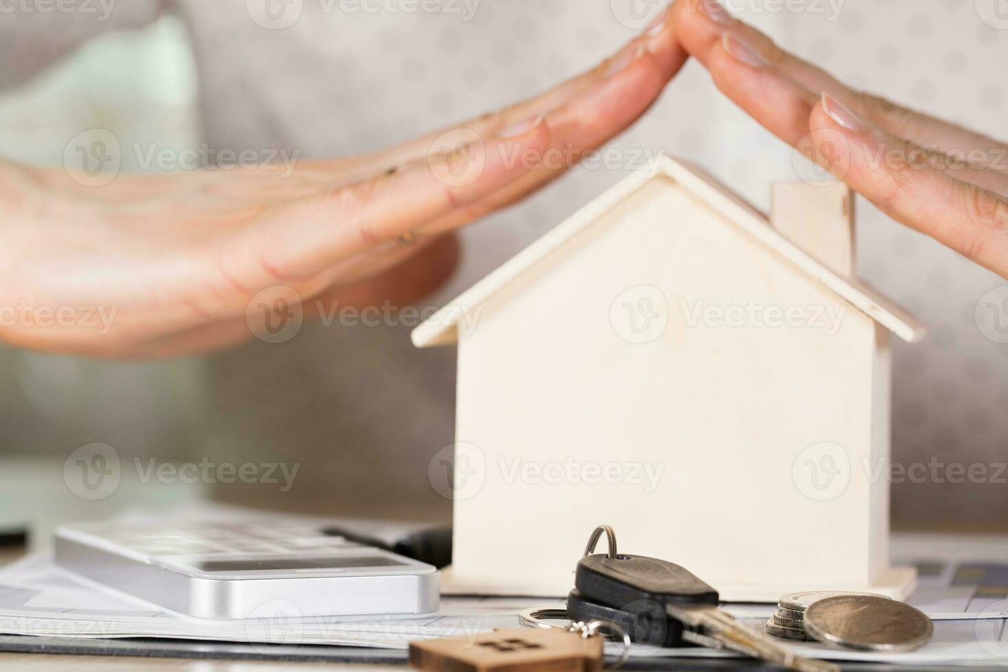 House keys and coins in front of a wooden house. photo