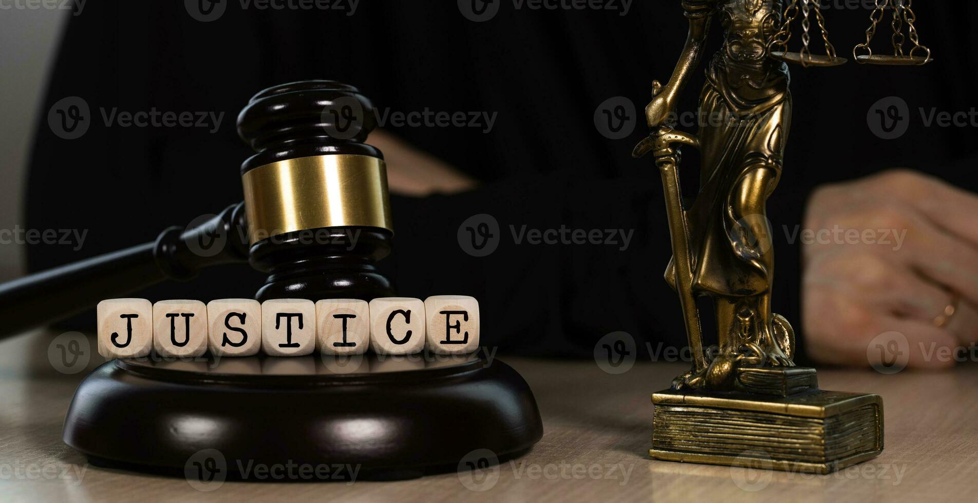 Word JUSTICE composed of wooden dices. Wooden gavel and statue of Themis in the background. photo