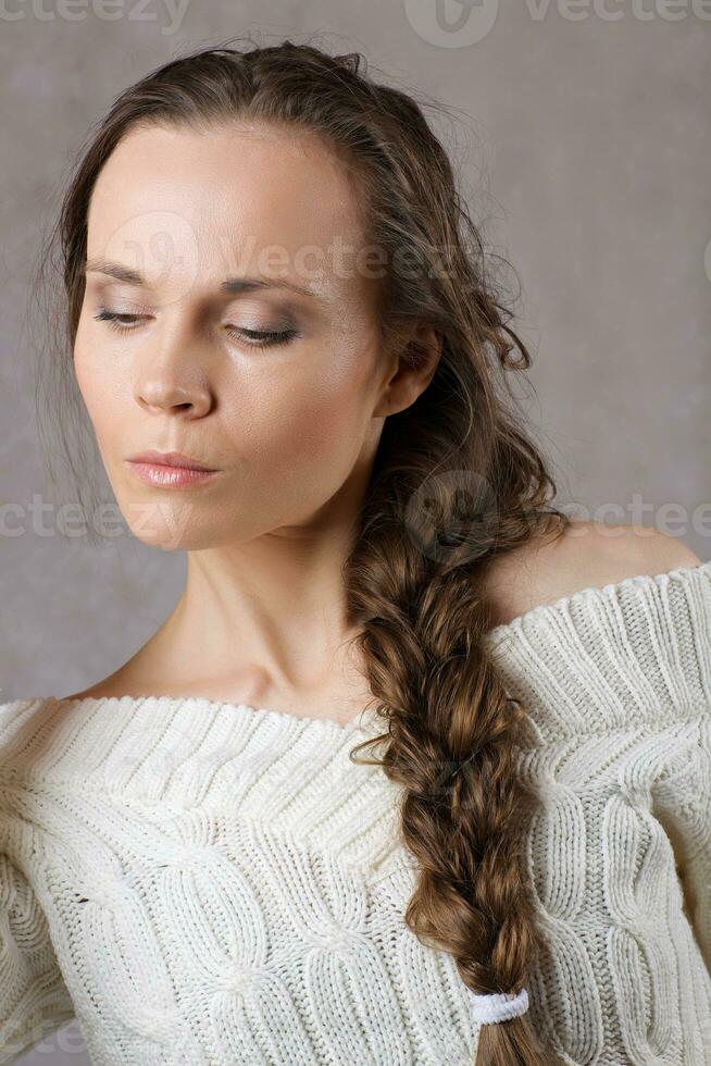 Young lady dressed in knitted sweater. Closeup photo