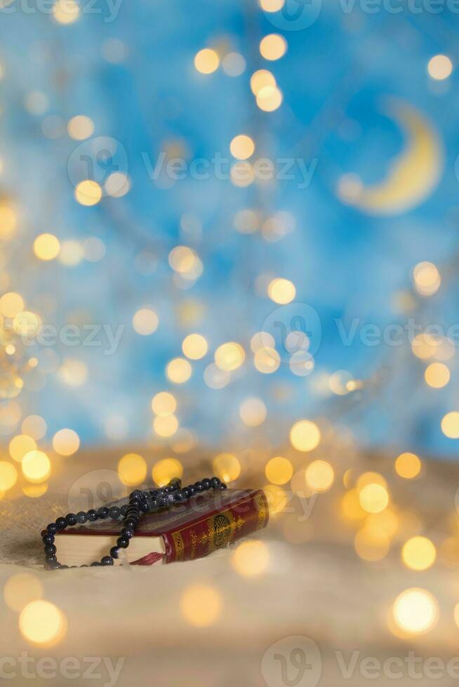 Holy book of Quran and praying beads on it. photo