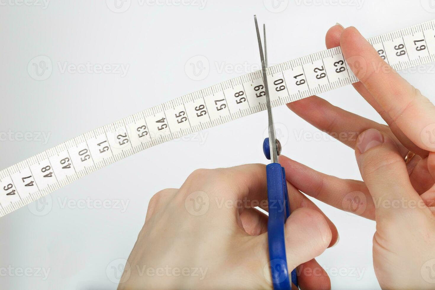 Scissors is cutting measuring band photo