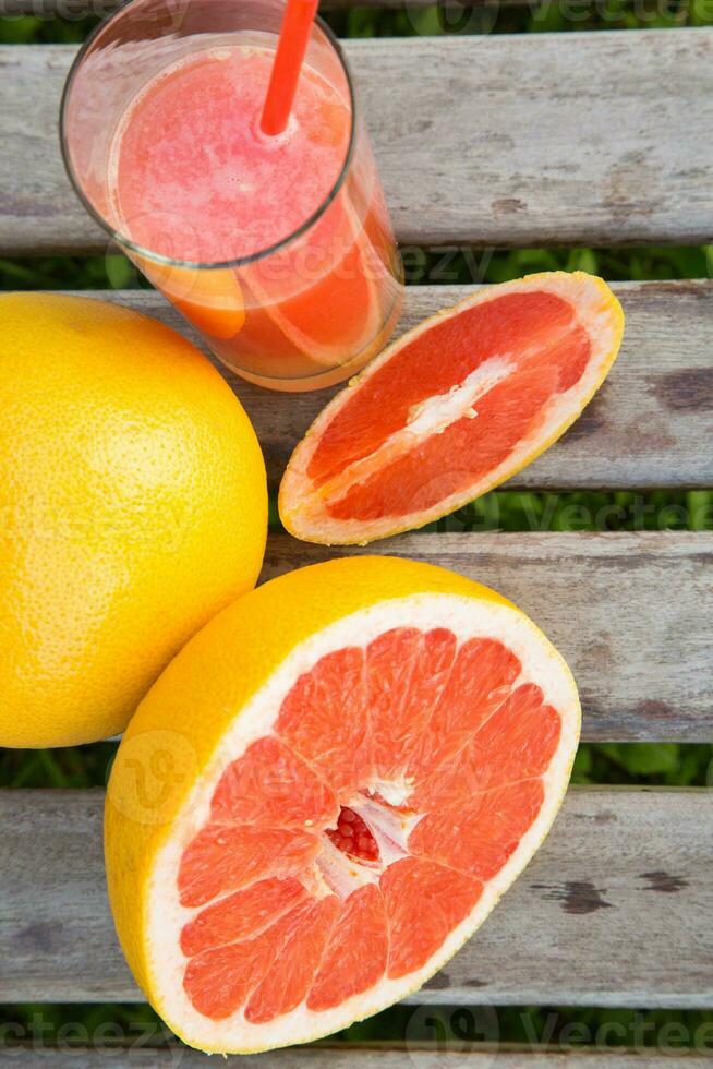 Pieces of grapefruit and a glass of fresh squeezed grapefruit juice.Top view photo