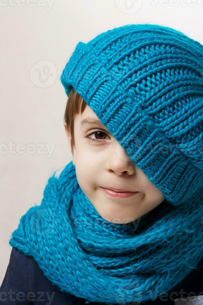 Six years old child in cyan knitted scarf and hat. photo