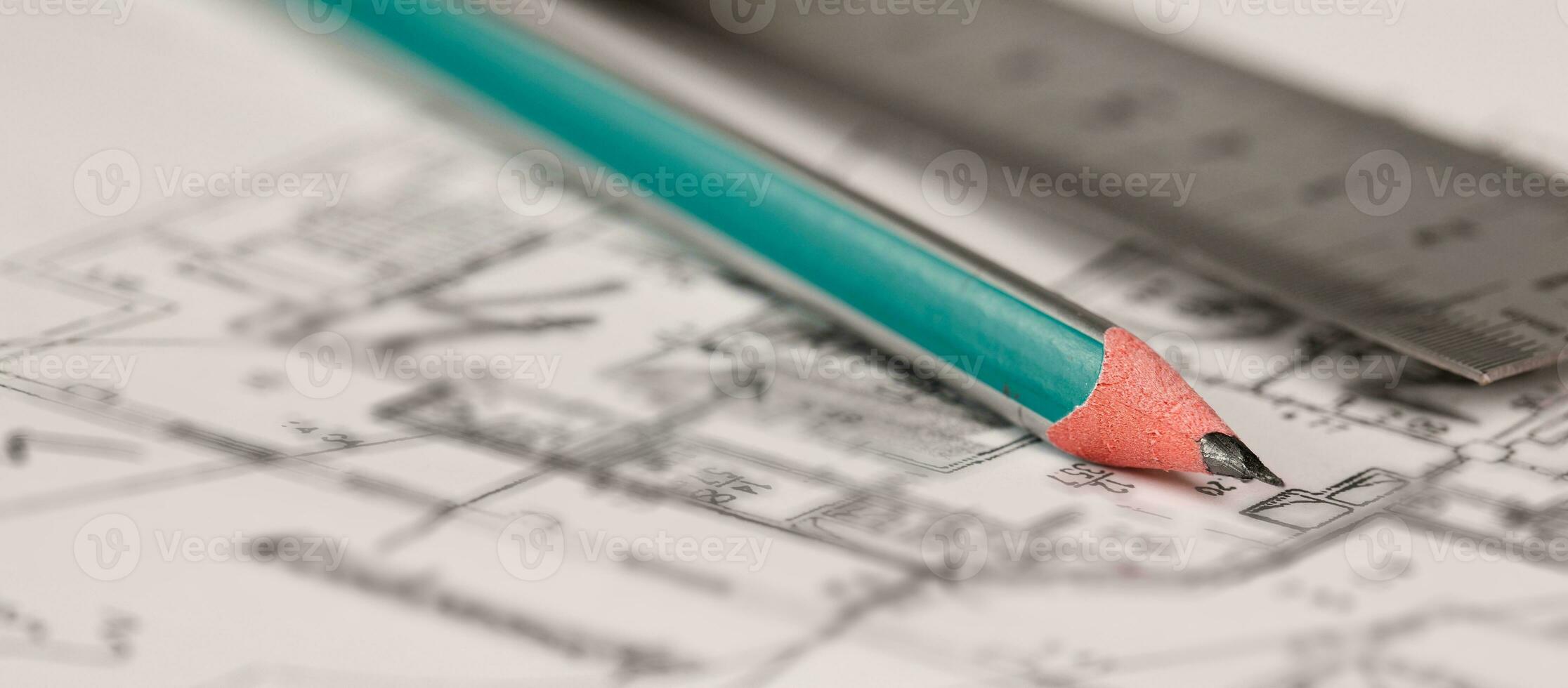 Coal pencil and metal ruler on a technical drawing of an apartment. photo