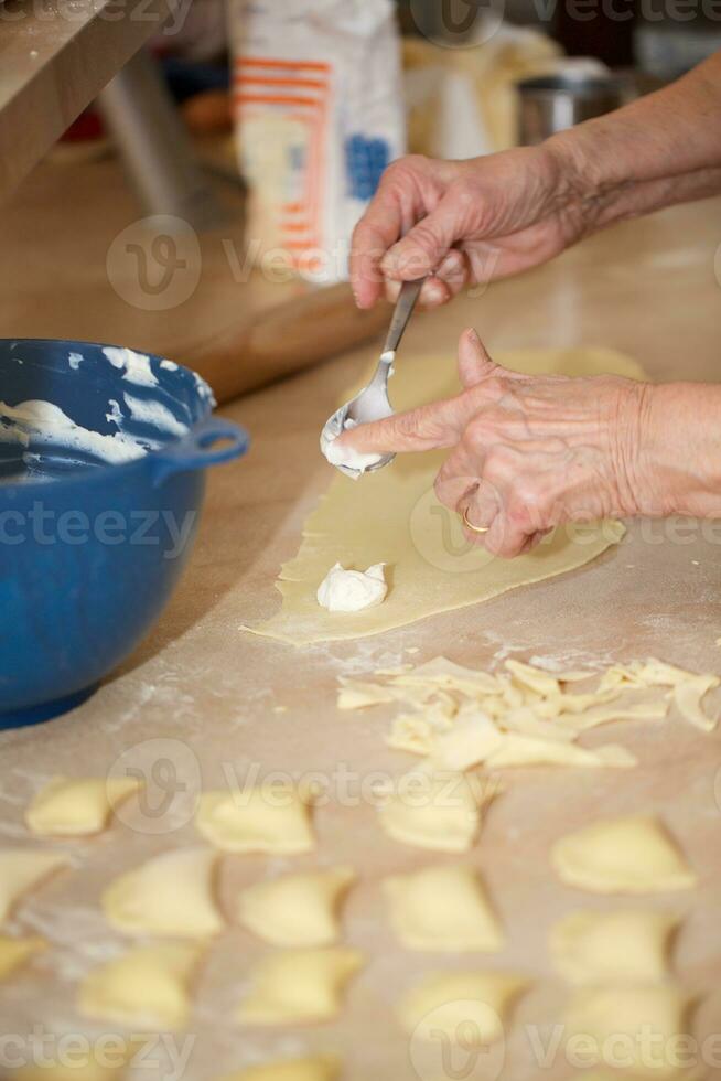 antiguo mujer es preparando hecho en casa Ravioles con queso foto