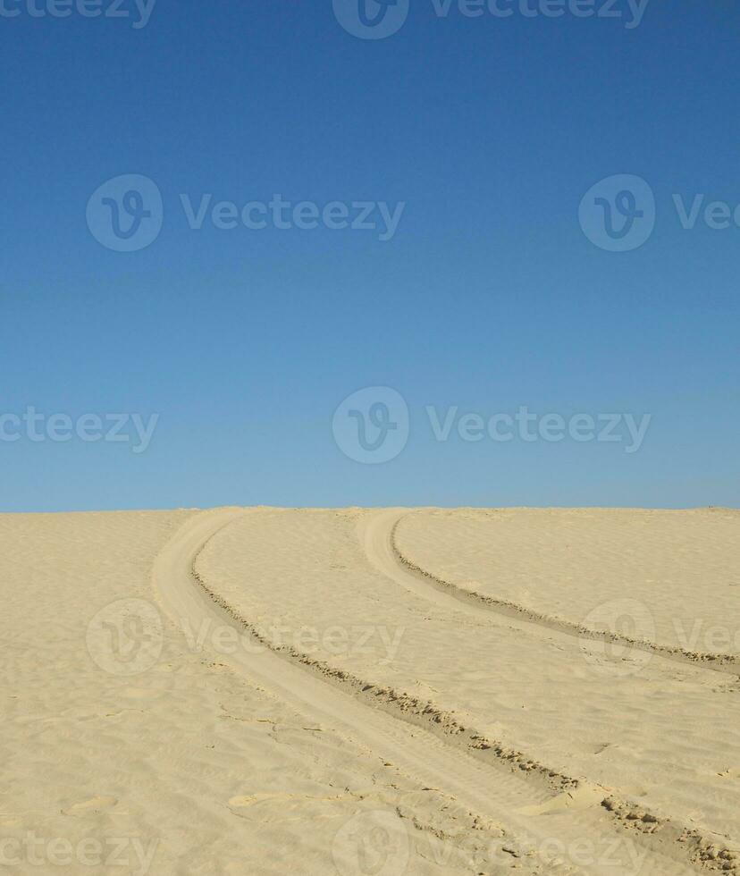 Tyre tracks on a sand surface photo