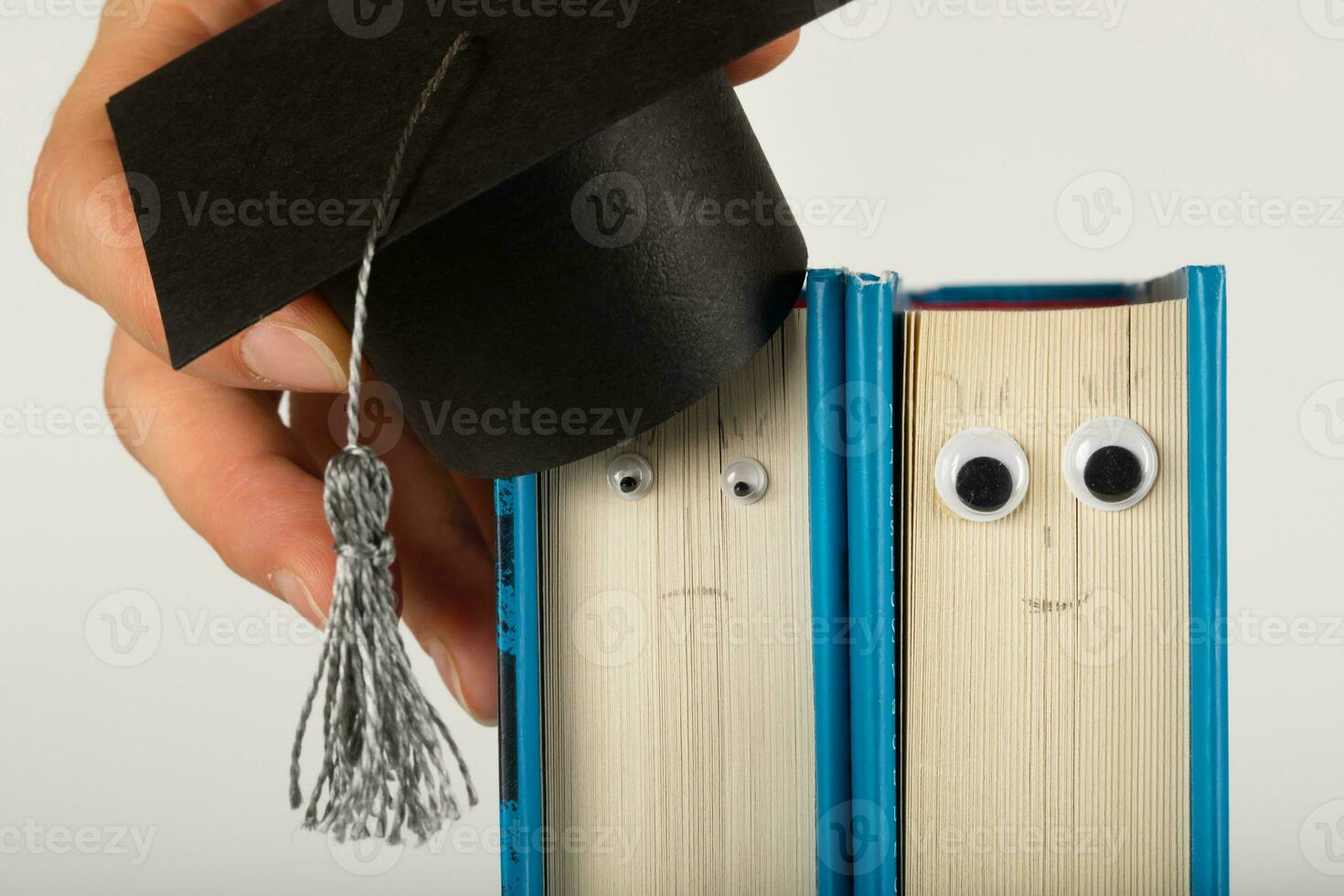 Academic hat on the book. Sad and happy emotions. photo