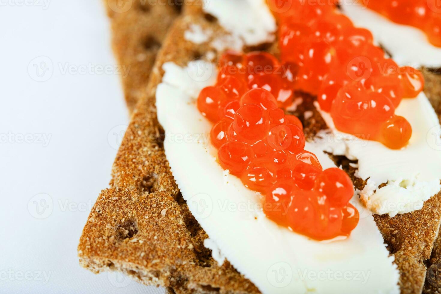 Cereal crispbread crackers with butter and red caviar. photo