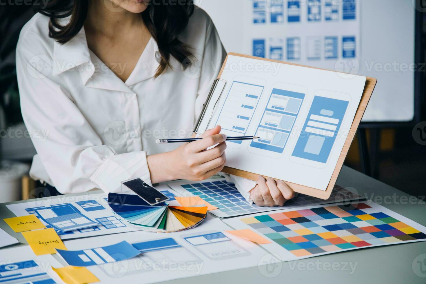 Close up ux developer and ui designer brainstorming about mobile app interface wireframe design on table with customer breif and color code at modern office.Creative digital development agency photo