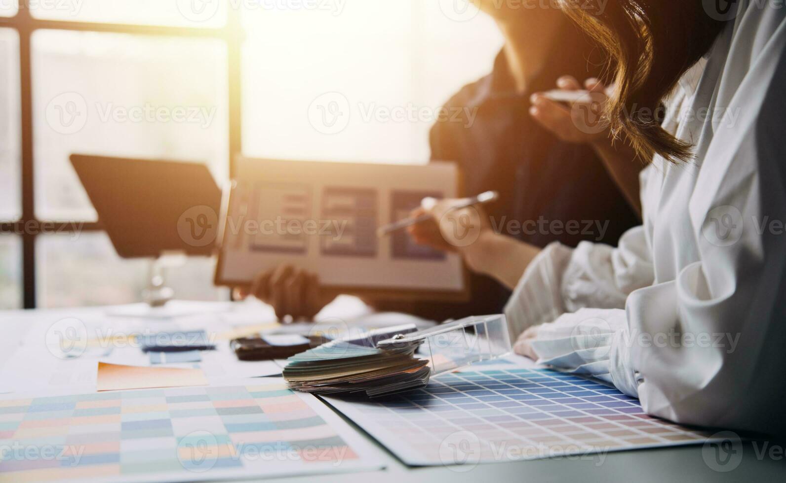 Close up ux developer and ui designer brainstorming about mobile app interface wireframe design on table with customer breif and color code at modern office.Creative digital development agency photo