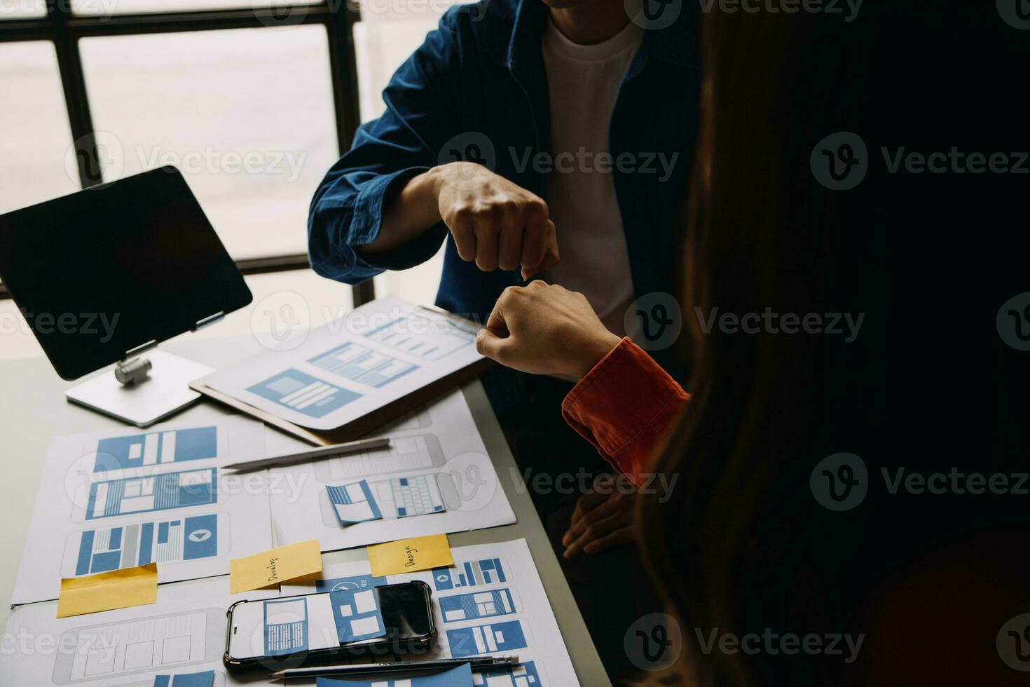 Close up ux developer and ui designer brainstorming about mobile app interface wireframe design on table with customer breif and color code at modern office.Creative digital development agency photo