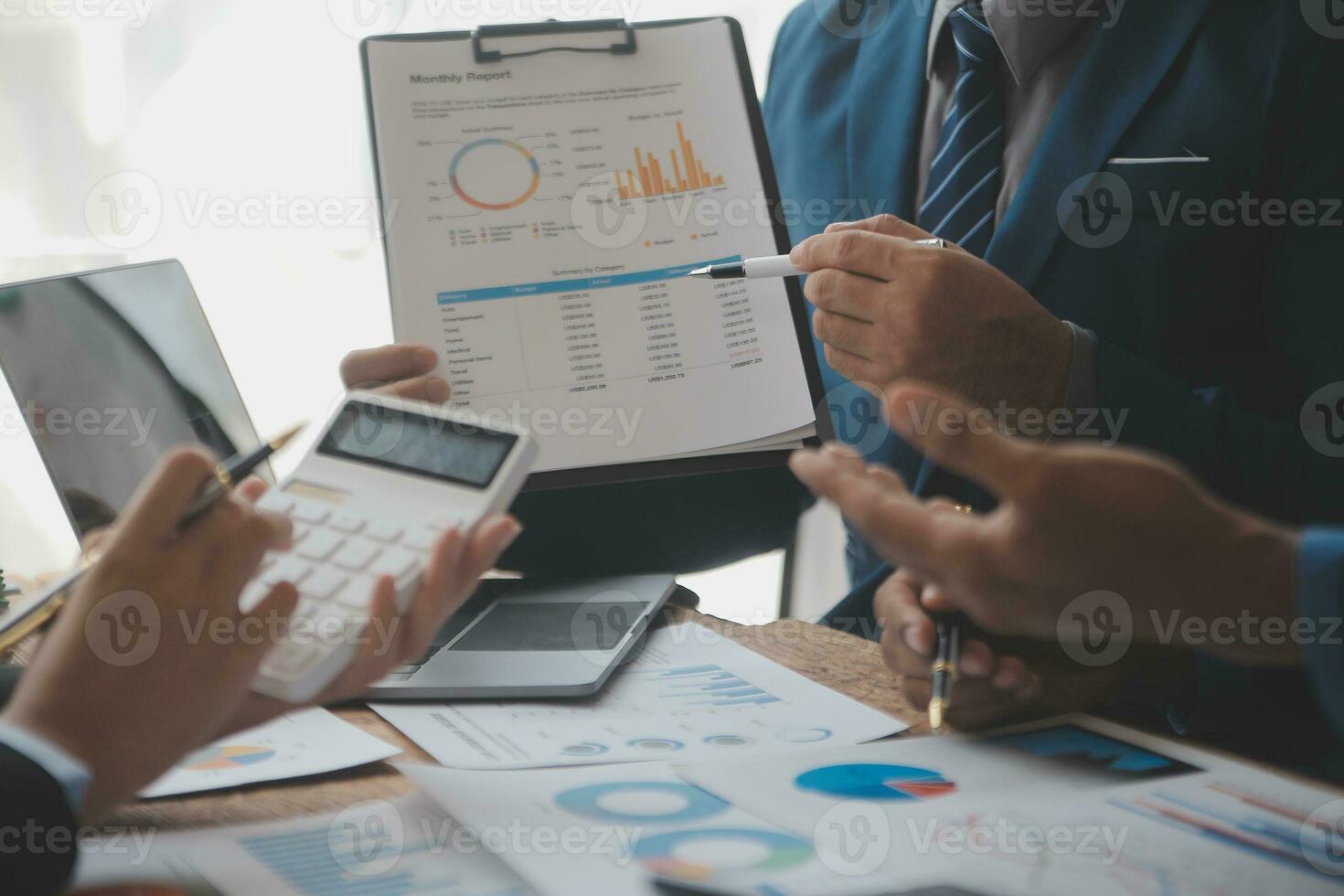 Financial analysts analyze business financial reports on a digital tablet planning investment project during a discussion at a meeting of corporate showing the results of their successful teamwork. photo