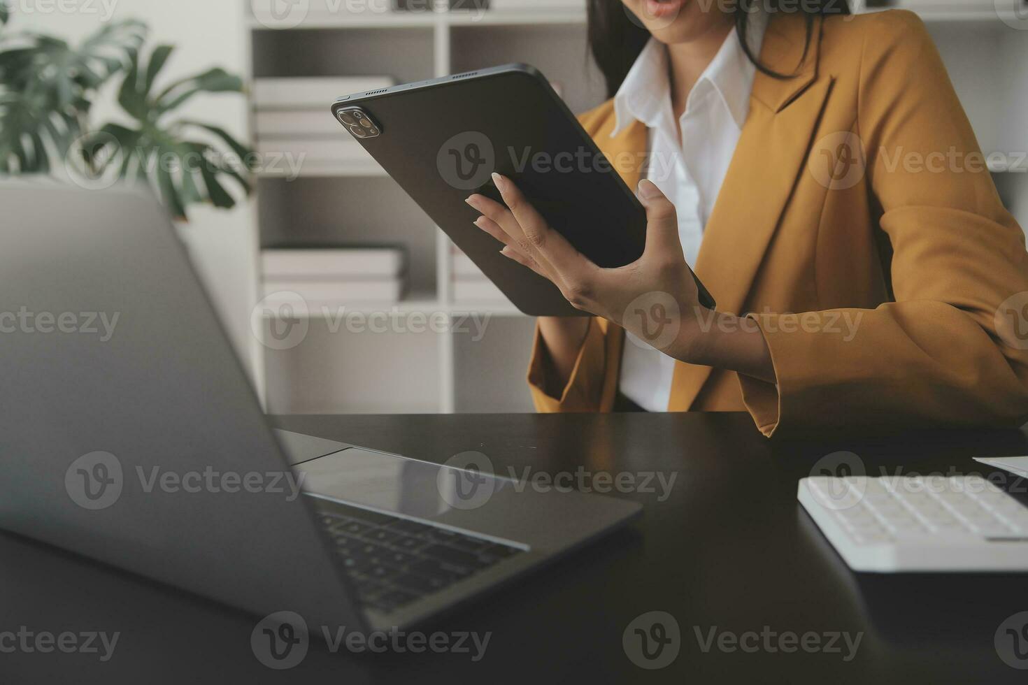 Asian Business woman using calculator and laptop for doing math finance on an office desk, tax, report, accounting, statistics, and analytical research concept photo