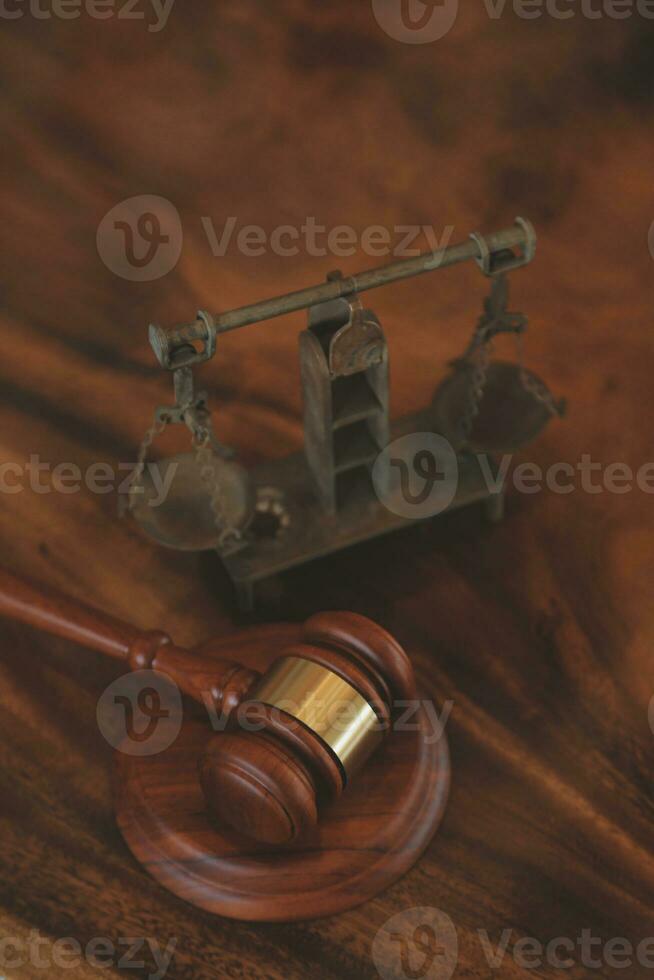 law books and scales of justice on desk in library of law firm. jurisprudence legal education concept. photo