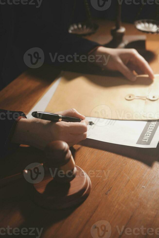 law books and scales of justice on desk in library of law firm. jurisprudence legal education concept. photo