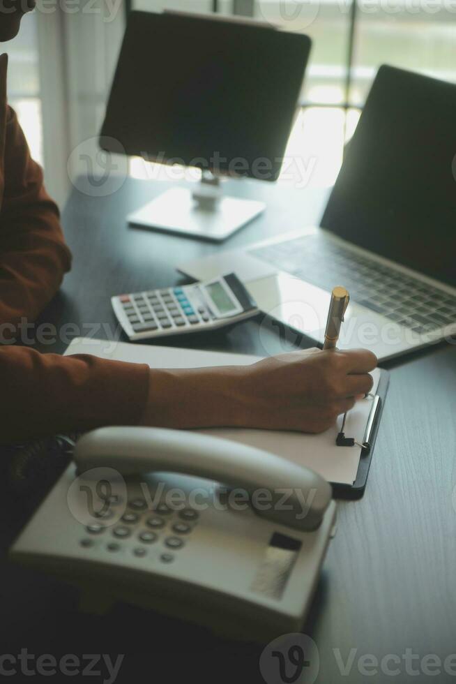 Close up Business woman using calculator and laptop for do math finance on wooden desk, tax, accounting, statistics and analytical research concept photo