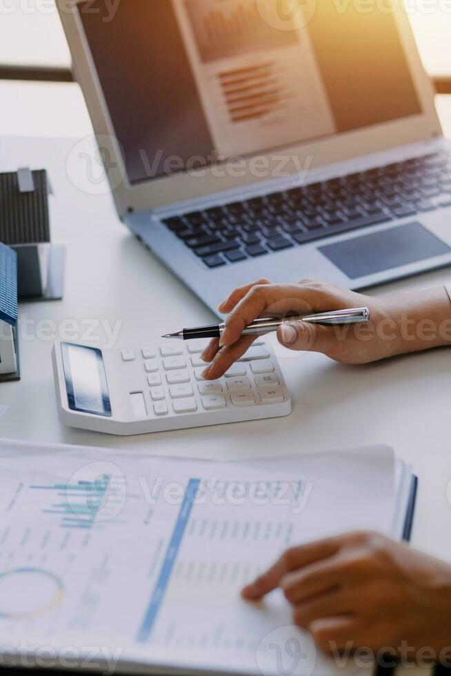 businessman working on desk office with using a calculator to calculate the numbers, finance accounting concept photo