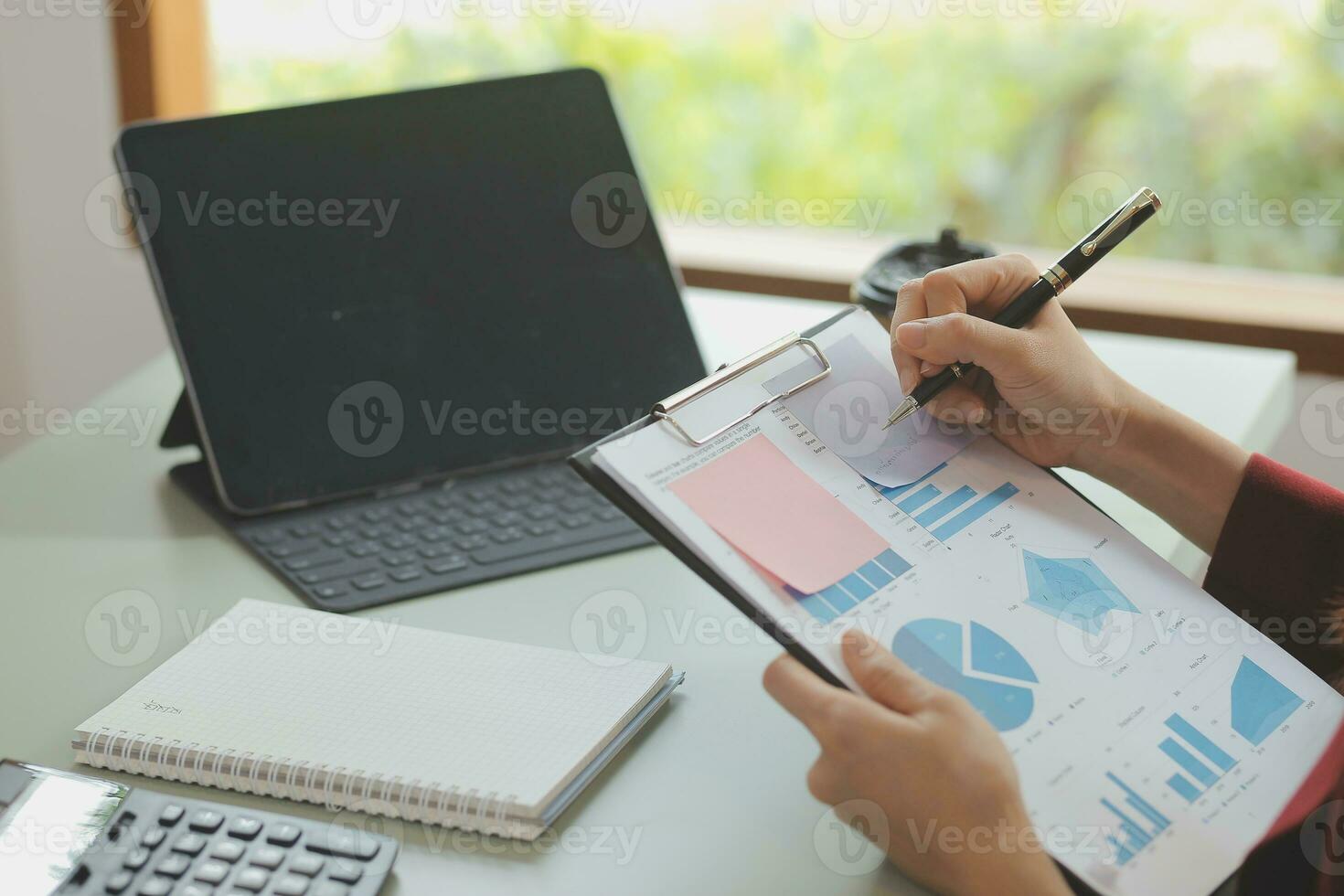 Asian Business woman using calculator and laptop for doing math finance on an office desk, tax, report, accounting, statistics, and analytical research concept photo