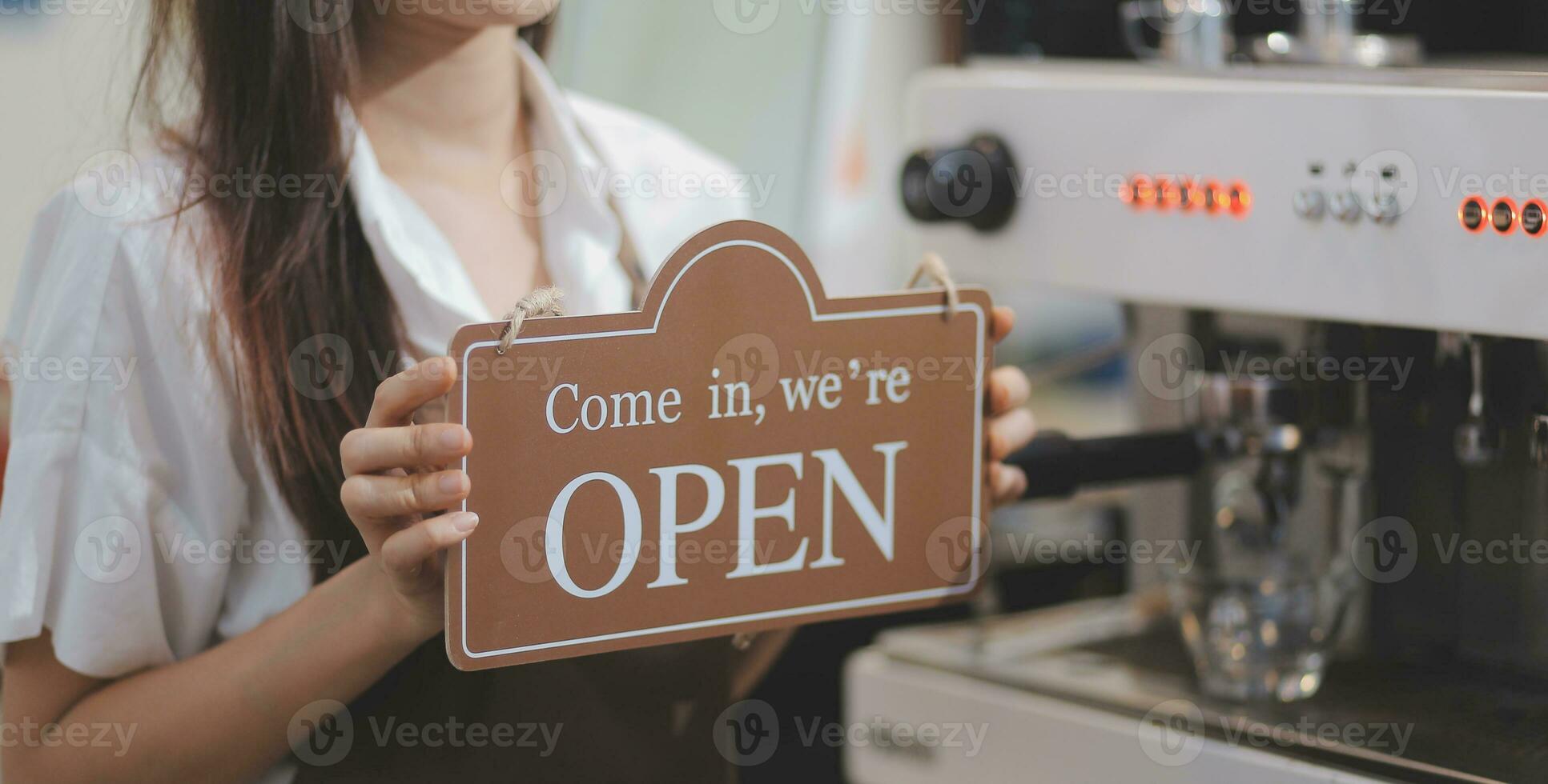 Welcome. Open. barista, waitress woman turning open sign board on glass door in modern cafe coffee shop ready to service, cafe restaurant, retail store, small business owner, food and drink concept photo