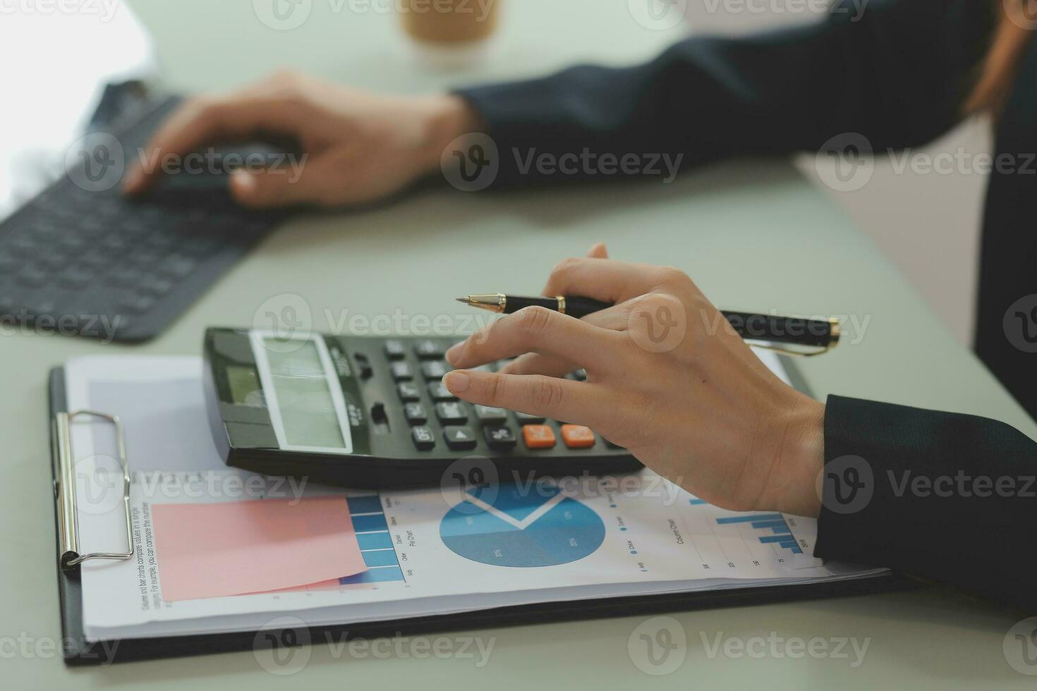 Asian Business woman using calculator and laptop for doing math finance on an office desk, tax, report, accounting, statistics, and analytical research concept photo