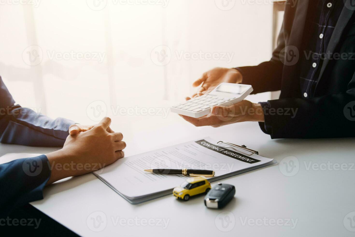 Man signing car insurance document or lease paper. Writing signature on contract or agreement. Buying or selling new or used vehicle. Car keys on table. Warranty or guarantee. Customer or salesman. photo