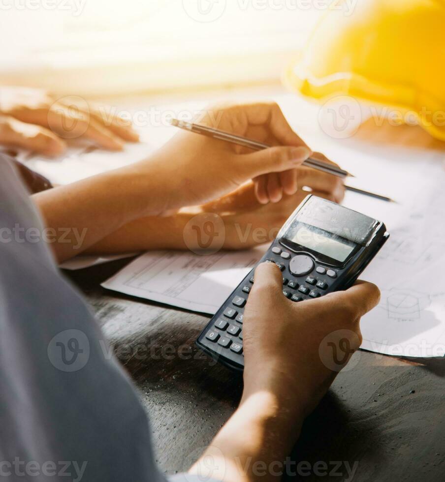 Two Specialists Inspect Commercial, Industrial Building Construction Site. Real Estate Project with Civil Engineer, Investor Use Laptop. In the Background Crane, Skyscraper Concrete Formwork Frames photo
